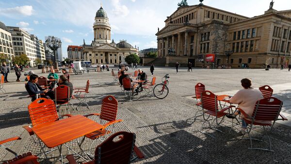 Люди наслаждаются погодой в кафе на площади Жандарменмаркт в Берлине, соблюдая принцип социальной дистанции - Sputnik Moldova-România