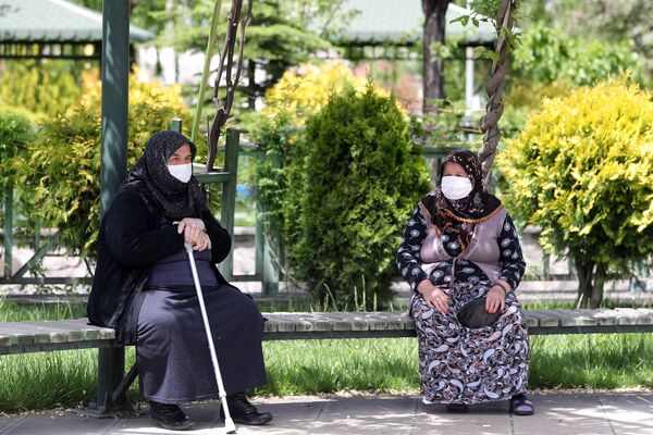 Пожилые женщины в медицинских масках на скамейке в одном из парков Анкары, Турция - Sputnik Молдова