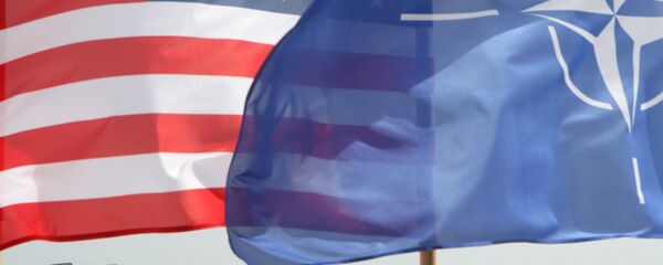 The US and The NATO flag flie in front of two US Air Force F-22 Raptor fighter aircrafts at the Air Base of the Lithuanian Armed Forces in Šiauliai, Lithuania, on April 27, 2016.  - Sputnik Moldova