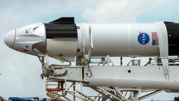 Crews work on the SpaceX Crew Dragon, attached to a Falcon 9 booster rocket, as it sits horizontal on Pad39A at the Kennedy Space Center in Cape Canaveral, Florida, U.S. May 26, 2020. - Sputnik Moldova-România