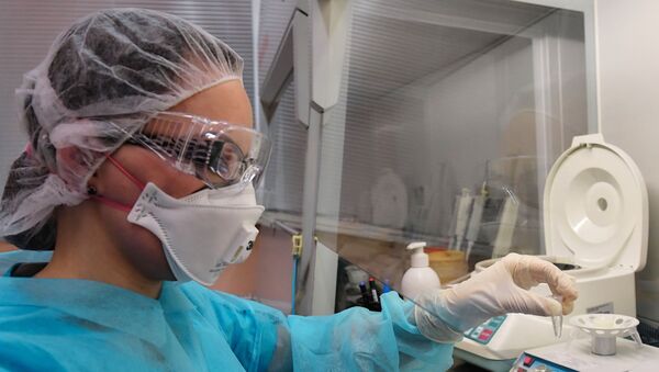 Сотрудник лаборатории во время тестирования проб на коронавирус. - Sputnik Молдова