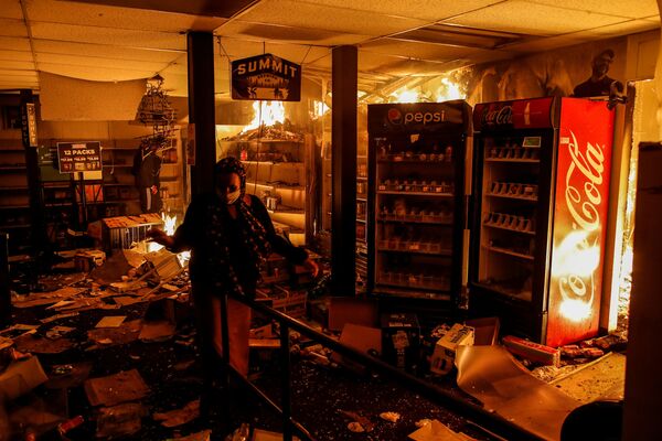 Женщина в сожженном магазине в Миннеаполисе, штат Миннесота, США - Sputnik Moldova-România
