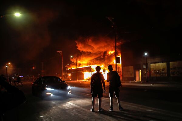 Люди смотрят на горящий магазин в Миннеаполисе, США - Sputnik Moldova-România