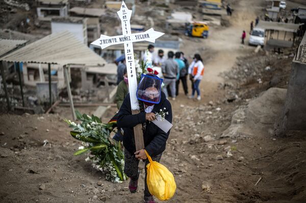 Родственник жертвы коронавируса несет крест по кладбищу на окраине Лимы, Перу - Sputnik Молдова