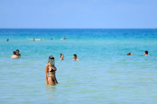 Женщина с защитным экраном на лице на пляже в Майами-Бич, Флорида - Sputnik Молдова