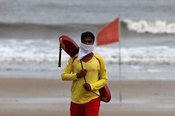 Спасатель в самодельной маске на пляже Джуу в Мумбаи, Индия - Sputnik Молдова