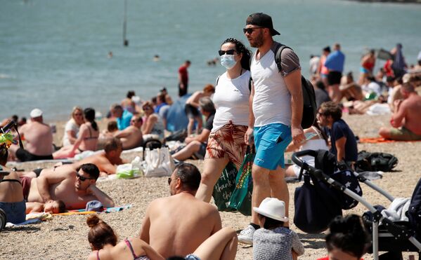 Пара в защитных масках на пляже в Саутенд-он-Си, Великобритания  - Sputnik Молдова