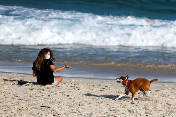Девушка во время игры с собакой на пляже в Рио-де-Жанейро, Бразилия  - Sputnik Молдова