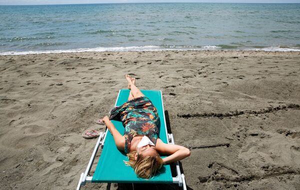 Девушка загорает на пляже в Италии - Sputnik Молдова