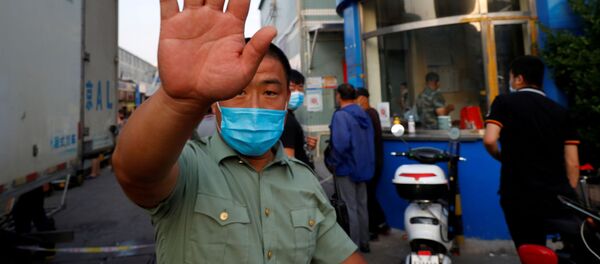 Un paznic în mască care încearcă să blocheze o hală lângă Piața de fructe de mare din Beijing - Sputnik Moldova-România