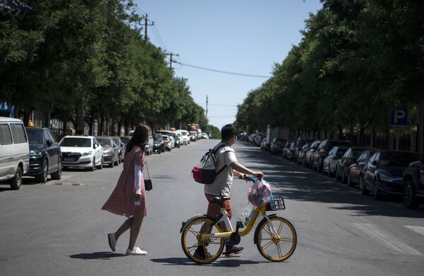 Un cuplu traversează strada din Complexul Yilanyuan din Beijing  închis din cauza carantinei - Sputnik Moldova-România