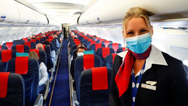 Стюардесса в медицинской маске в салоне самолета в международном аэропорту Брюсселя - Sputnik Moldova-România