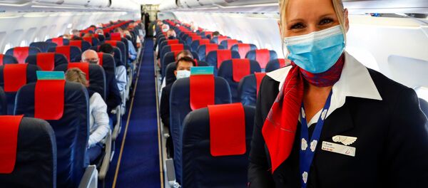 Стюардесса в медицинской маске в салоне самолета в международном аэропорту Брюсселя. - Sputnik Молдова