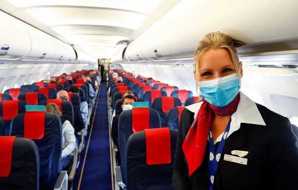 Стюардесса в медицинской маске в салоне самолета в международном аэропорту Брюсселя - Sputnik Молдова
