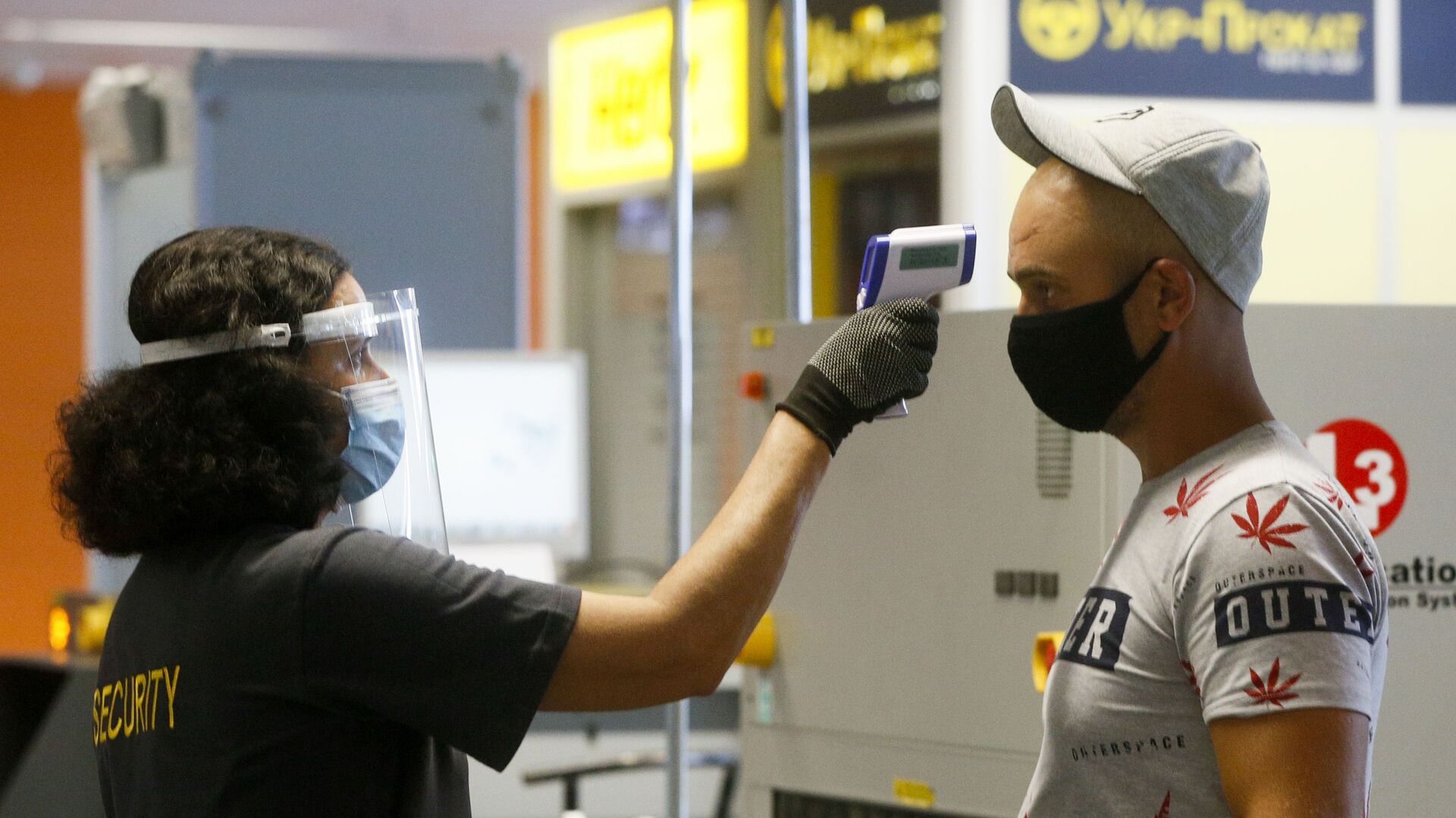 Пассажир в защитной маске проходит температурный контроль в международном аэропорту Борисполь в Киеве - Sputnik Moldova-România, 1920, 27.05.2021
