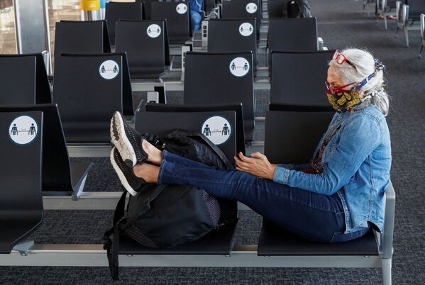 Пассажирка в защитной маске в терминале  международного аэропорта Брюсселя - Sputnik Молдова