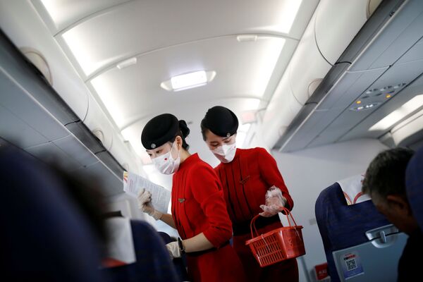Бортпроводницы в масках и перчатках на борту самолета авиакомпании Сычуань, Китай - Sputnik Молдова