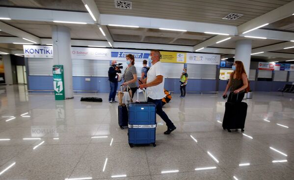 Туристы из Германии в медицинских масках в аэропорту Пальма-де-Майорка в Испании - Sputnik Молдова