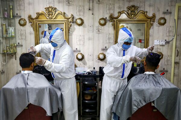 Барберы в защитных костюмах в одном из парикмахерских салонов Дакки, Бангладеш - Sputnik Молдова