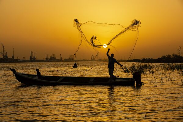  Рыбак закидывает сеть на закате на реке Шатт-эль-Араб в иракском городе Басра - Sputnik Молдова