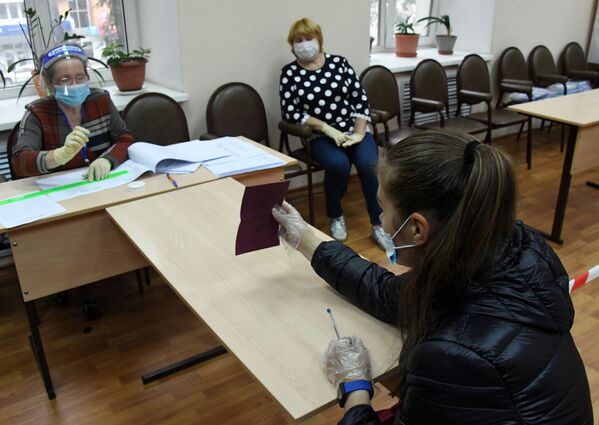 Член избирательной комиссии регистрирует участницу голосования по внесению поправок в Конституцию РФ на избирательном участке №727 во Владивостоке - Sputnik Moldova