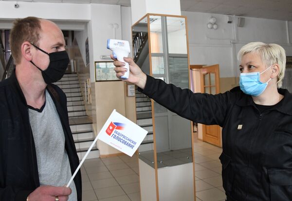 Измерение температуры участника голосования по внесению поправок в Конституцию РФ на избирательном участке №209 в Чите - Sputnik Moldova
