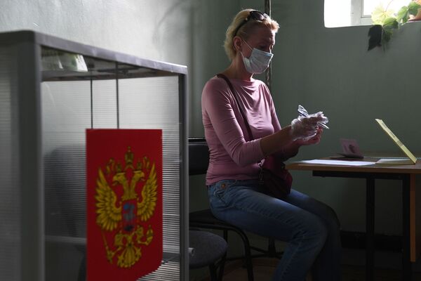 Женщина принимает участие в голосовании по внесению поправок в Конституцию РФ на избирательном участке №1503 в Новосибирске - Sputnik Moldova