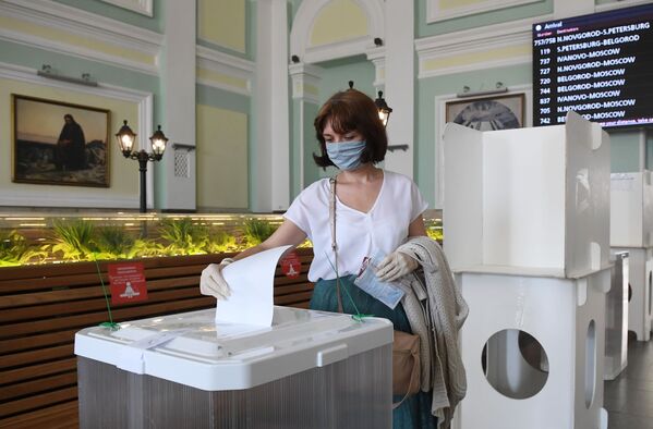 Женщина голосует по одобрению внесения поправок в Конституцию РФ на избирательном участке на Курском вокзале в Москве - Sputnik Moldova