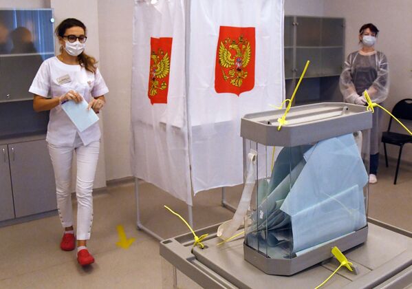 Медицинский работник принимает участие в голосовании по внесению поправок в Конституцию РФ на избирательном участке в Приморском краевом перинатальном центре во Владивостоке - Sputnik Moldova-România