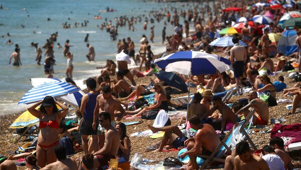 Люди наслаждаются жаркой погодой на пляже в Брайтоне, Великобритания - Sputnik Moldova-România