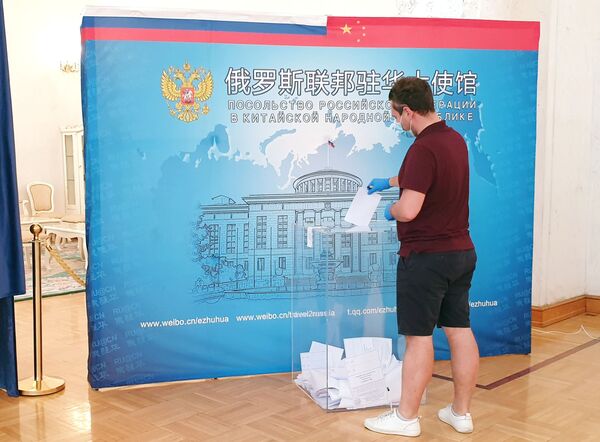 Мужчина голосует по вопросу одобрения изменений в Конституцию России на избирательном участке в посольстве РФ в Пекине - Sputnik Moldova-România