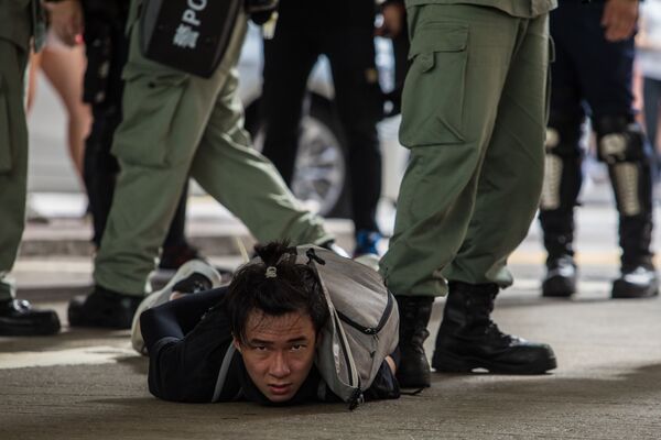 Задержанный полицией участник акции протеста против нового закона о национальной безопасности в Гонконге - Sputnik Молдова
