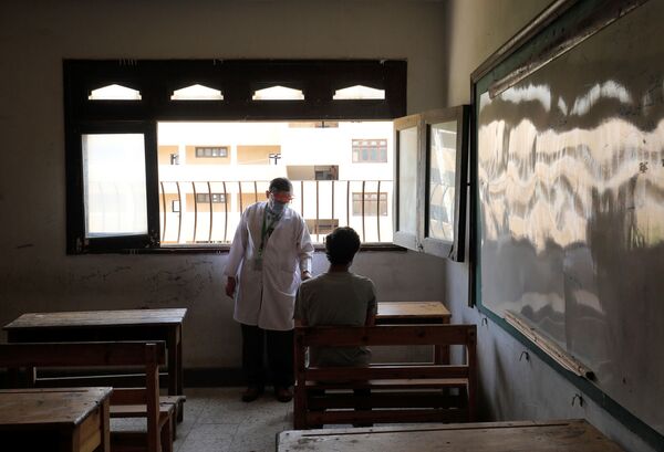Врач наблюдает за учеником в первый день выпускных экзаменов в Каире, Египет - Sputnik Молдова
