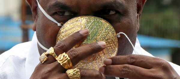 Житель индийского штата Махараштра Шанкар Кураде носит золотую защитную маску на фоне распространения коронавируса Житель индийского штата Махараштра Шанкар Кураде носит золотую защитную маску на фоне распространения коронавируса - Sputnik Молдова