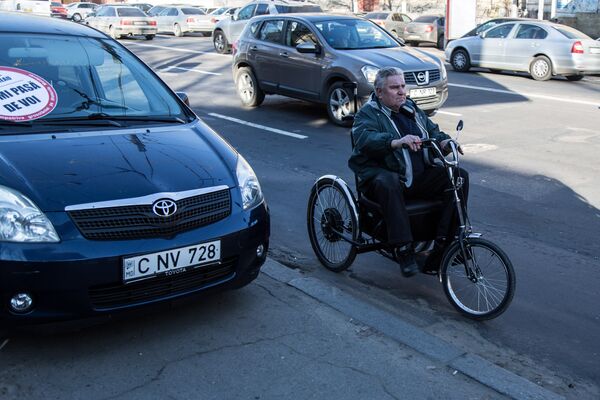 Руководитель Ассоциации инвалидов и пенсионеров Молдовы Валерий Марцун пытается по дороге объехать автомобиль, припаркованный на тротуаре вопреки ПДД. - Sputnik Молдова