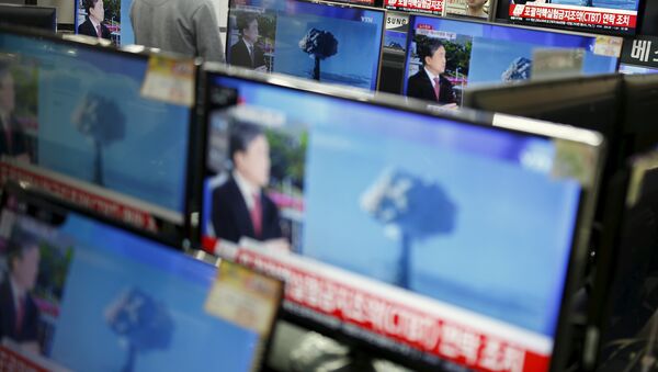 A sales assistant watches TV sets broadcasting a news report on North Korea's nuclear test, in Seoul, January 6, 2016 - Sputnik Moldova-România