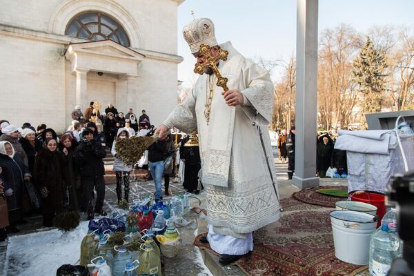 Предстоятель молдавской православной церкви освящает емкости с водой, принесенные прихожанами. - Sputnik Молдова