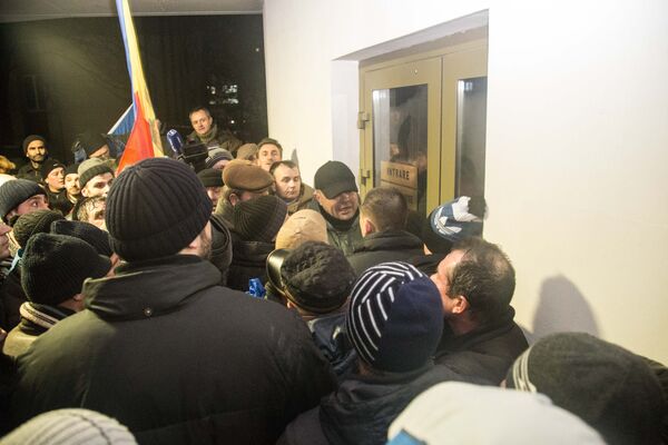 Затем полиции пришлось отступить в здание, а пикетчики принялись выламывать дверь. - Sputnik Молдова