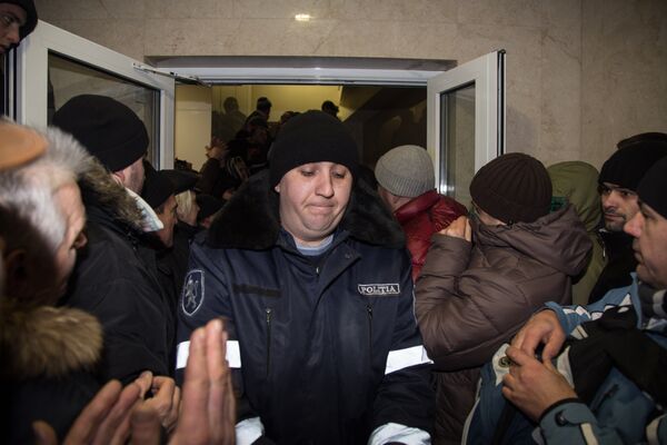 А пока что протестующие провожают аплодисментами полицейских, которые добровольно сложили оружие и покинули кордон. - Sputnik Молдова