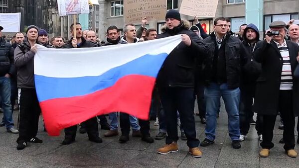СПУТНИК_Кельнцы с флагами РФ вышли на митинг из-за инцидента с девочкой в Берлине - Sputnik Молдова