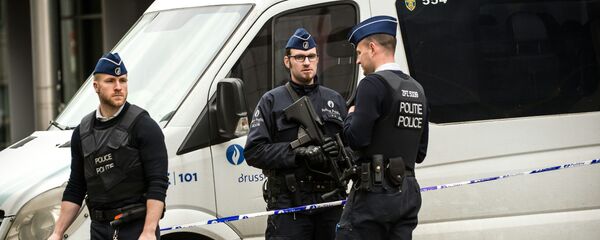 Policemen stand guard at the entrance of a security perimeter set in the Rue de la Loi near the Maalbeek subway station, in Brussels, on March 22, 2016 - Sputnik Молдова