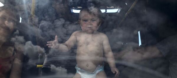 Ребенок в салоне автобуса на пограничном пункте пропуска Изварино в Луганской области Ребенок в салоне автобуса на пограничном пункте пропуска Изварино в Луганской области - Sputnik Moldova-România