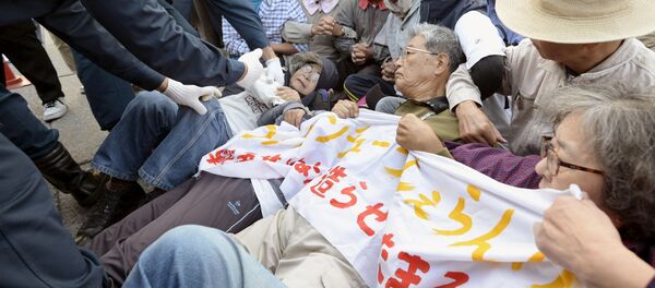 Protesters lie on the ground as they try to block work on a contentious U.S. air base in front of the gate of the U.S. Marine Corps Camp Schwab in Nago on the southern Japanese island of Okinawa - Sputnik Moldova