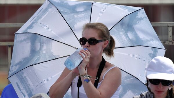 Женщина прячется от солнца под зонтом - Sputnik Moldova