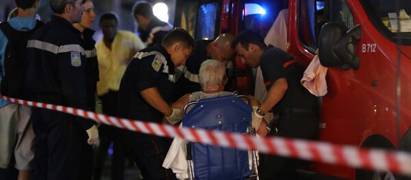 Rescue workers help an injured woman to get in a ambulance on July 15, 2016, after a truck drove into a crowd watching a fireworks display in the French Riviera town of Nice. - Sputnik Moldova