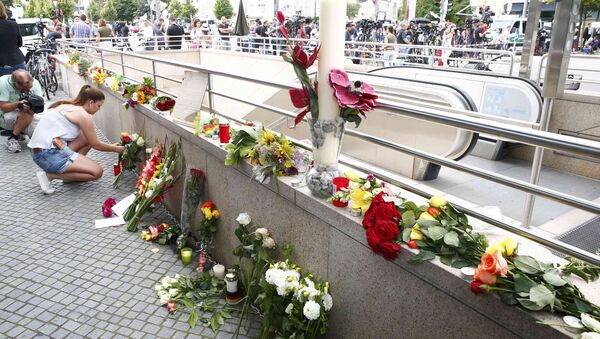 A women places flowers near the Olympia shopping mall, where yesterday's shooting rampage started, in Munich, Germany July 23, 2016. - Sputnik Moldova-România