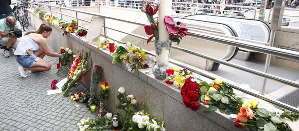 A women places flowers near the Olympia shopping mall, where yesterday's shooting rampage started, in Munich, Germany July 23, 2016. - Sputnik Moldova
