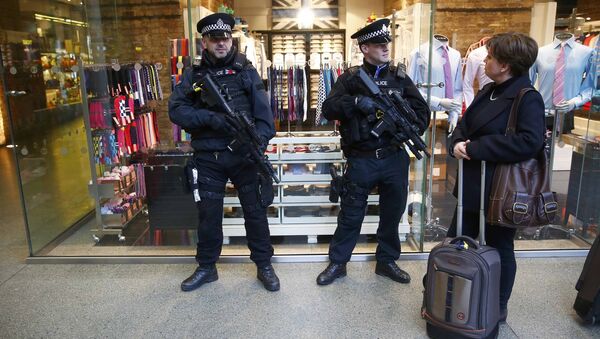 A passenger chats to armed police officers on patrol after Eurostar trains to Brussels were cancelled at St Pancras station in central London, Britain. - Sputnik Moldova-România