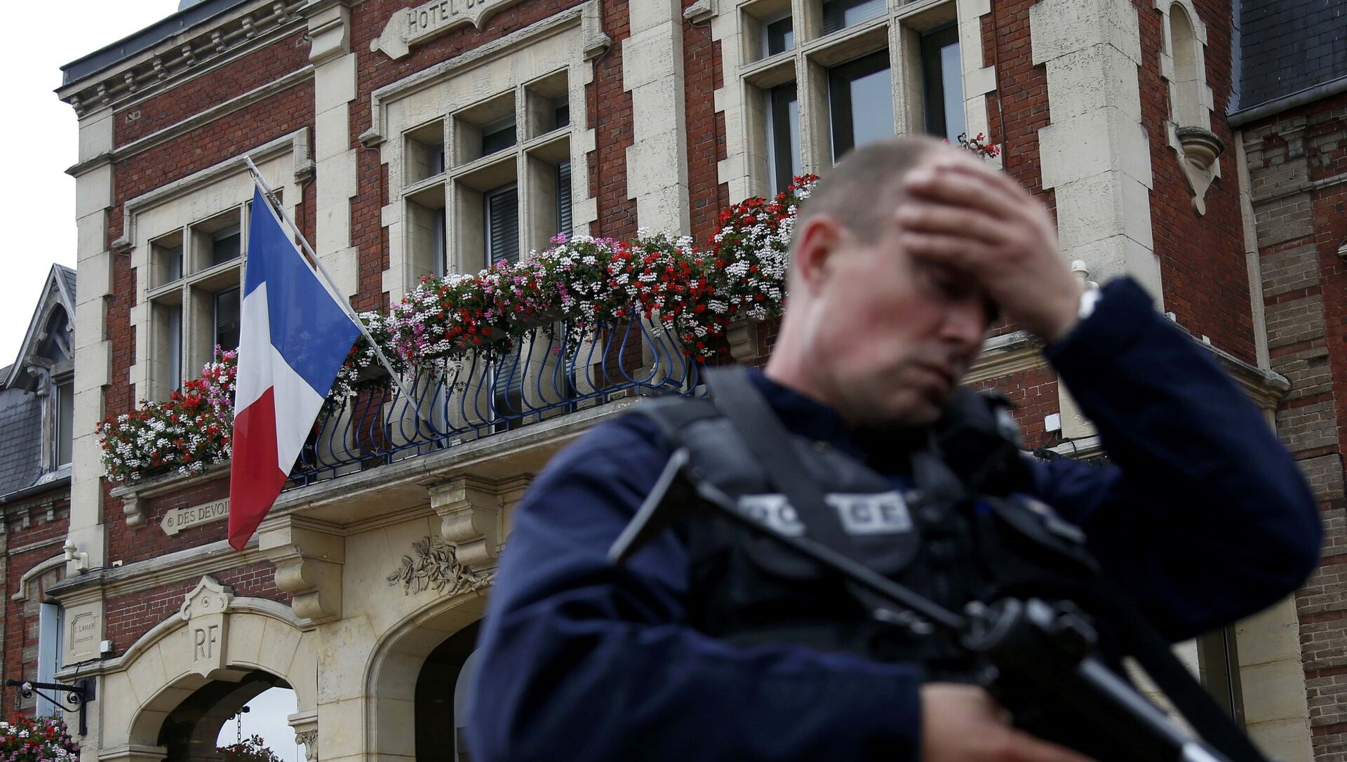 A policeman reacts as he secures a position in front of the city hall after two assailants had taken five people hostage in the church at Saint-Etienne-du -Rouvray near Rouen in Normandy, France, July 26, 2016.  - Sputnik Moldova-România, 1920, 22.06.2021