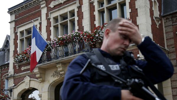 A policeman reacts as he secures a position in front of the city hall after two assailants had taken five people hostage in the church at Saint-Etienne-du -Rouvray near Rouen in Normandy, France, July 26, 2016.  - Sputnik Moldova-România